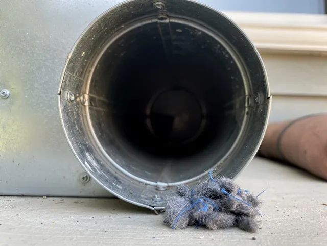 Manchester Dryer Vent Cleaning technician using specialized equipment to clear severe dryer vent blockage in Manchester